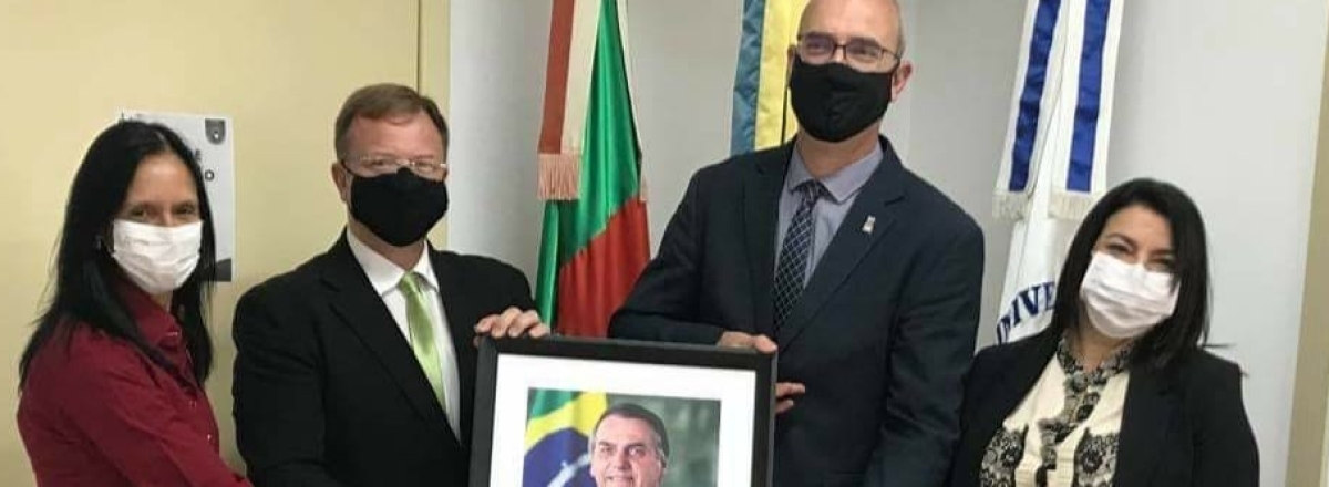 Futuro reitor da UFSM recebe quadro com foto do presidente Bolsonaro